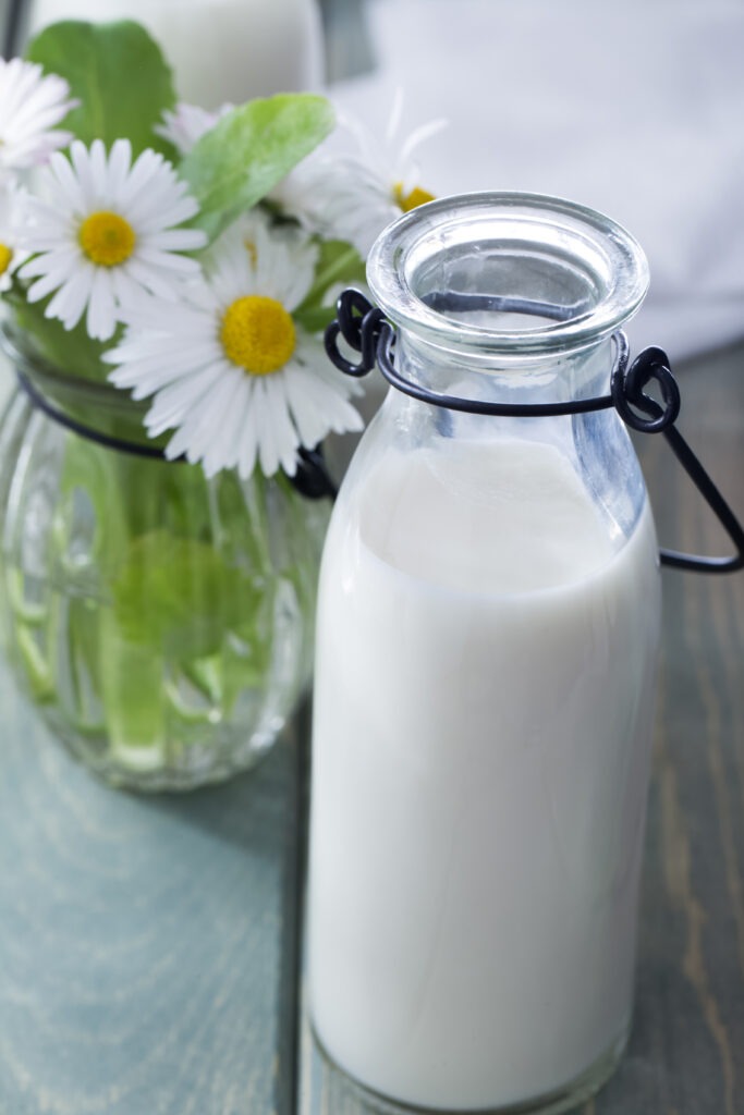 bottle of milk and summer flowers on wood backgrou 2024 10 16 15 21 43 utc